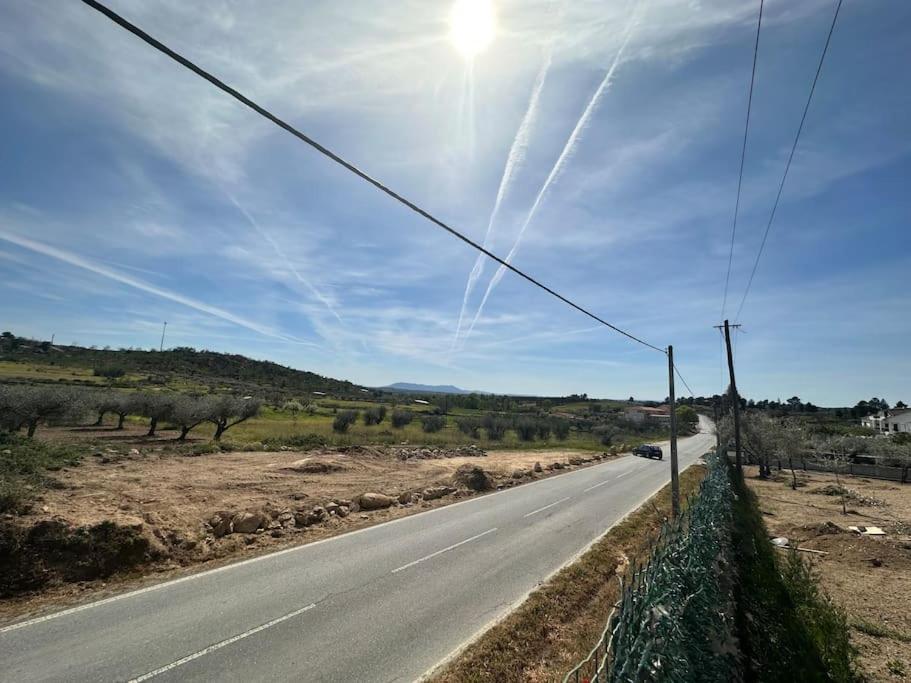 an empty road with the sun in the sky at Reis House in Torre de Dona Chama