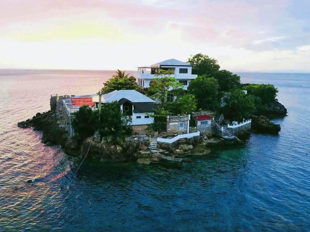 een huis op een klein eiland in het water bij Utopia Island Resort in Batangas City