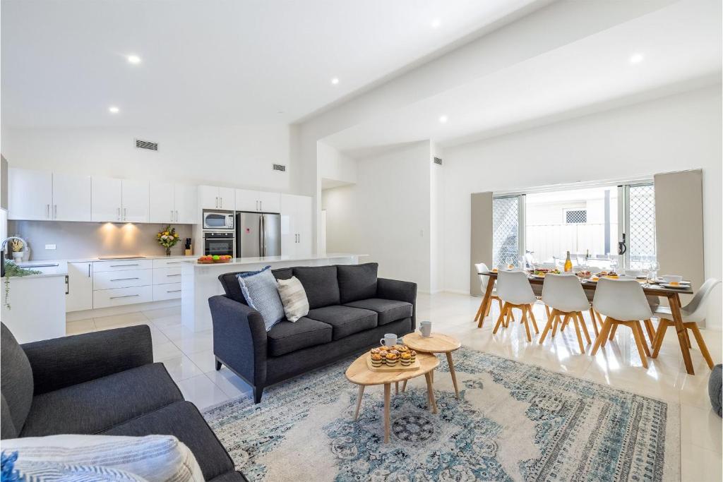 ein Wohnzimmer mit einem Sofa und einem Tisch in der Unterkunft Daze on Dowling 25b Dowling Street WiFi, Air Conditioning 700 metres to the water in Nelson Bay