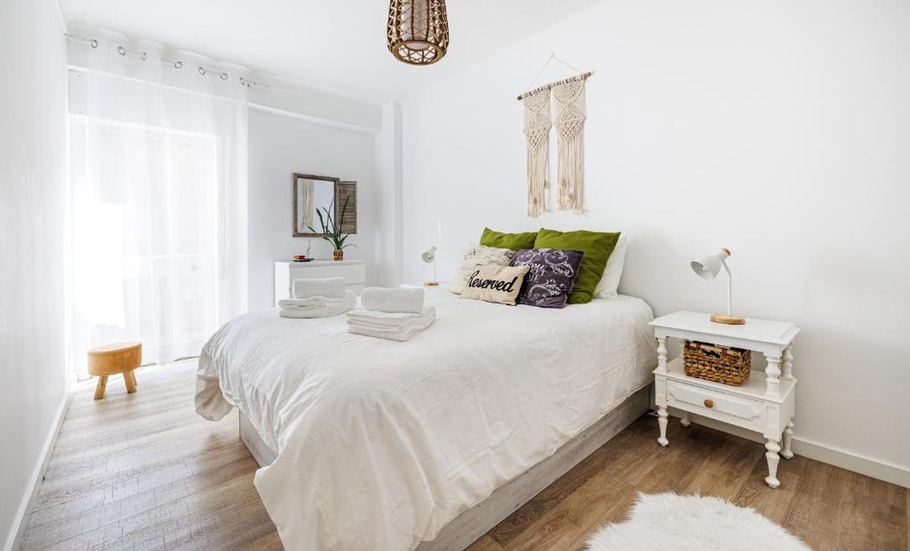 a white bedroom with a bed and a window at COZY BOHO HOUSE, Elegance & Comfort in Faro Center in Faro
