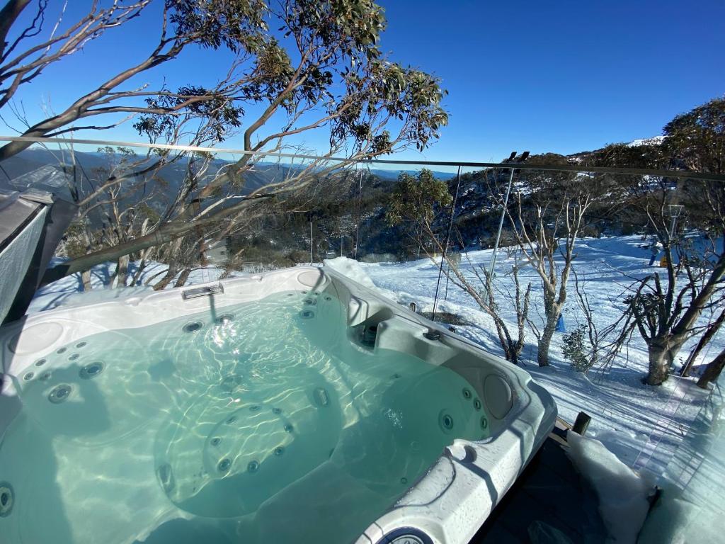 a jacuzzi tub with snow on the ground at Frostwood in Mount Buller