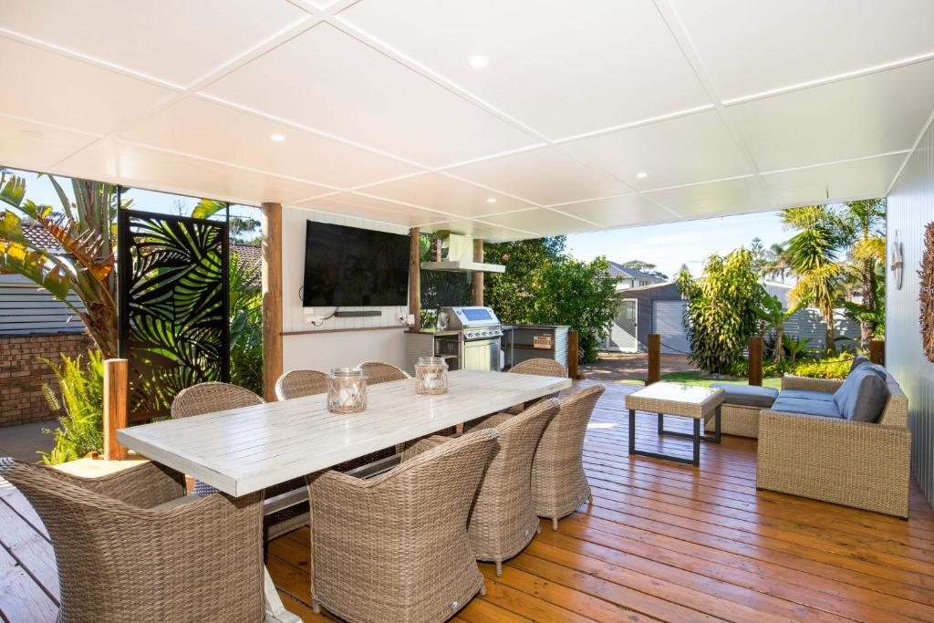 a dining room with a white table and chairs at The Anchor - Pet Friendly - 5 Mins Walk to Beach - EV Charging in Callala Beach