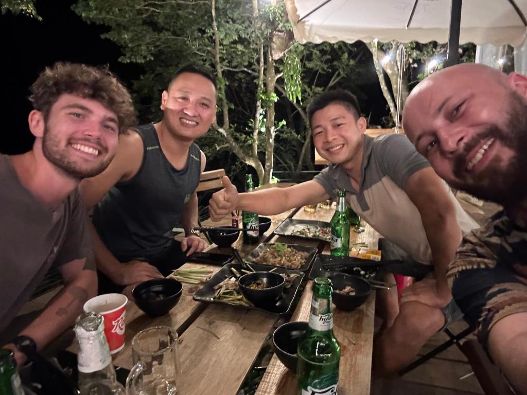 a group of men sitting around a table with food at Retro Khe Sanh in Lao Bao