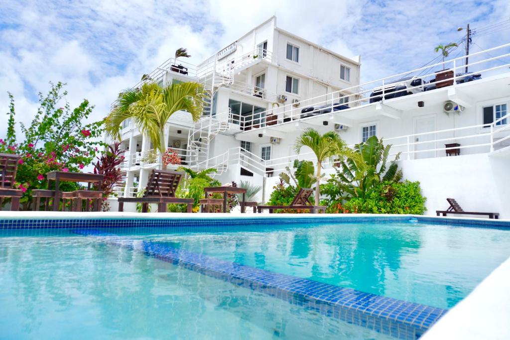 羅阿坦的住宿－Ocean View Hotel and Restaurant，一座白色大建筑前的游泳池