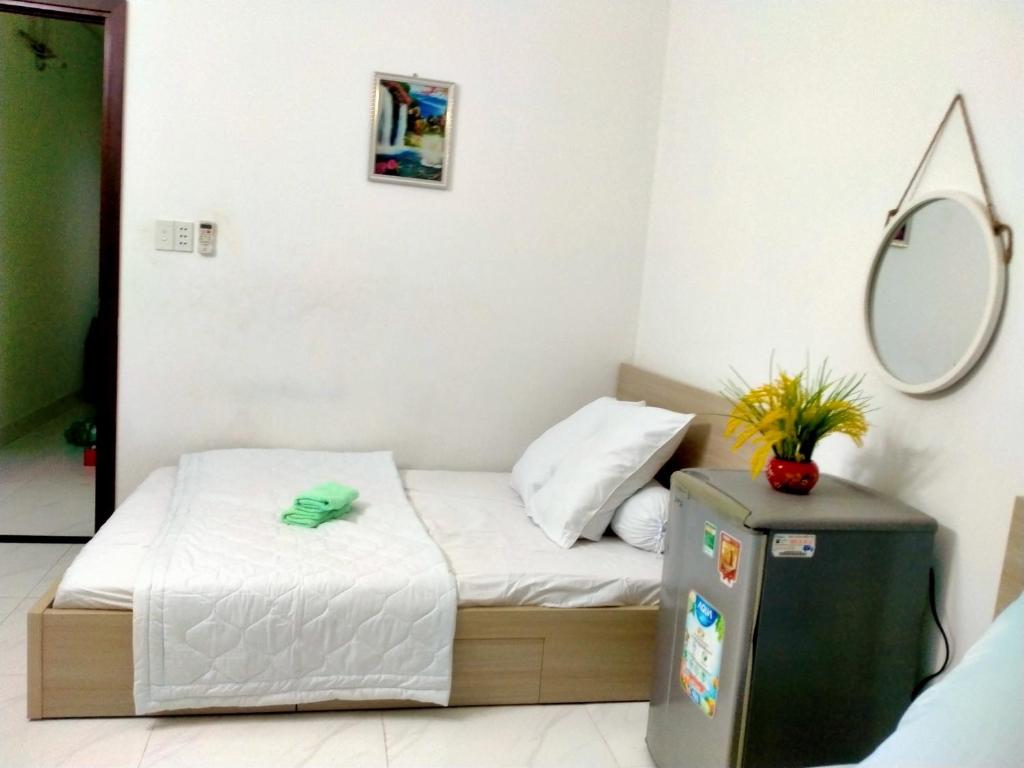 ein kleines Schlafzimmer mit einem Bett und einem Spiegel in der Unterkunft Traveler’s choice home in Vietnam 1 in Củ Chi