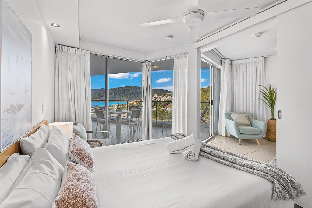 a bedroom with a large bed with a view of the ocean at Serenity Views in Airlie Beach