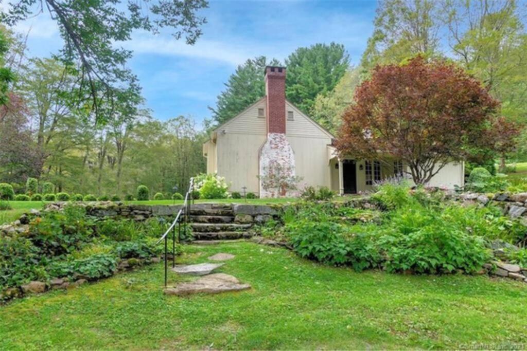 的住宿－Cottage Retreat - Historic Cottage Home w Home Gym，一座古老的白色房子,在院子里设有一个花园