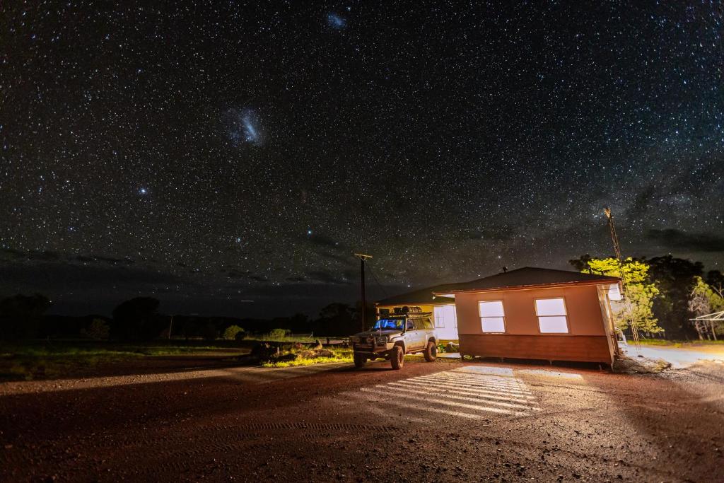 Ein LKW parkt neben einem kleinen Gebäude unter einem Sternenhimmel in der Unterkunft Bendleby Ranges in Belton