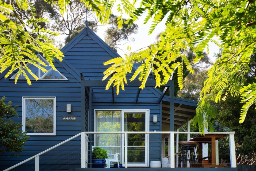 a blue house with white windows and a porch at Amaris in Daylesford