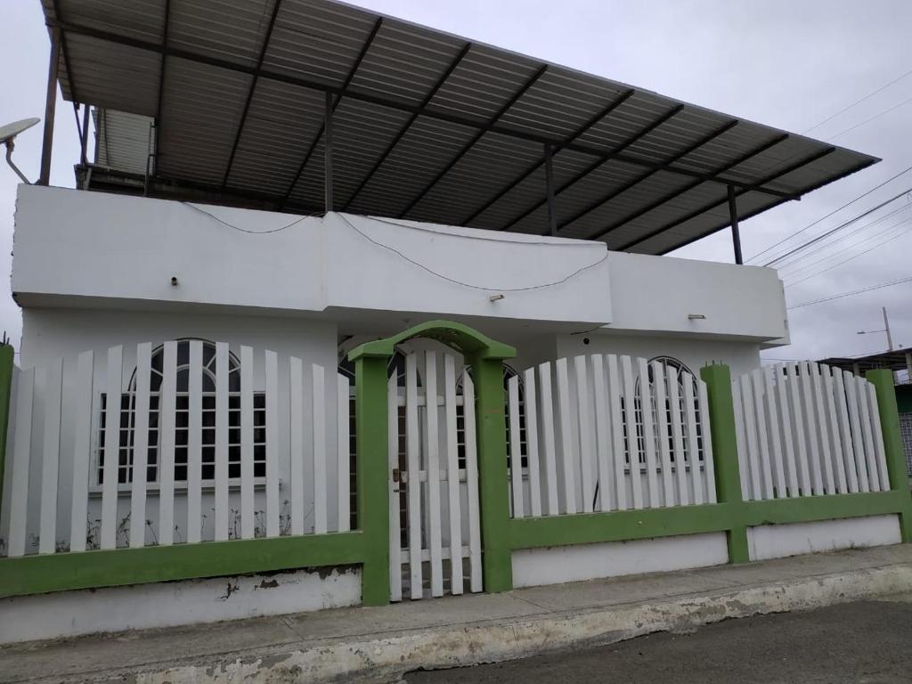 une clôture blanche et verte devant un bâtiment dans l'établissement Suite Magy-Manta, à Manta
