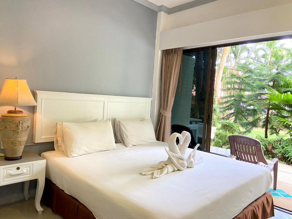 a hotel room with a bed with a window at Garden Home Kata in Kata Beach
