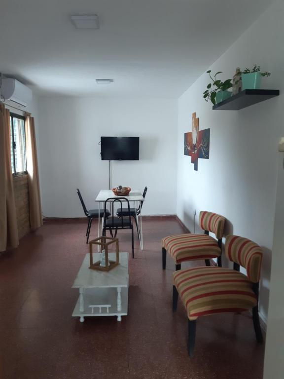 a living room with chairs and a table and a tv at Sarratea 1427 in Santiago del Estero