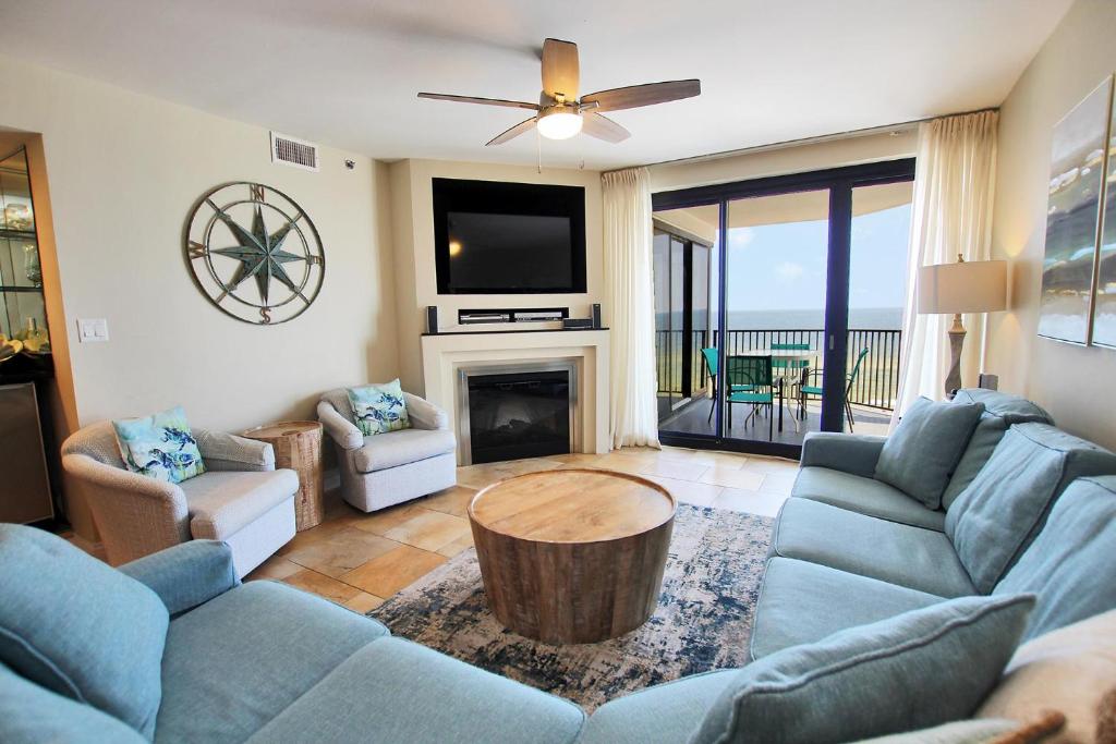 a living room with a couch and a table and a tv at Broadmoor 304 in Orange Beach