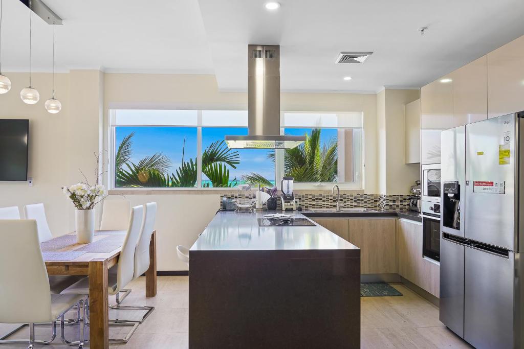 a kitchen with a kitchen island with a dining table at LUXURIOUS APARTMENT IN LEVENT FRONT EAGLE BEACH in Palm-Eagle Beach