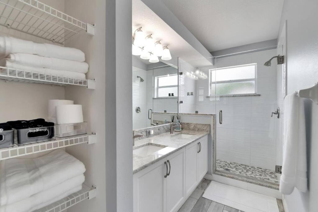 a white bathroom with a sink and a mirror at Elegant Comfort - Newly Updated 3BR with Cozy Master Suite - Pet Friendly in Tarpon Springs