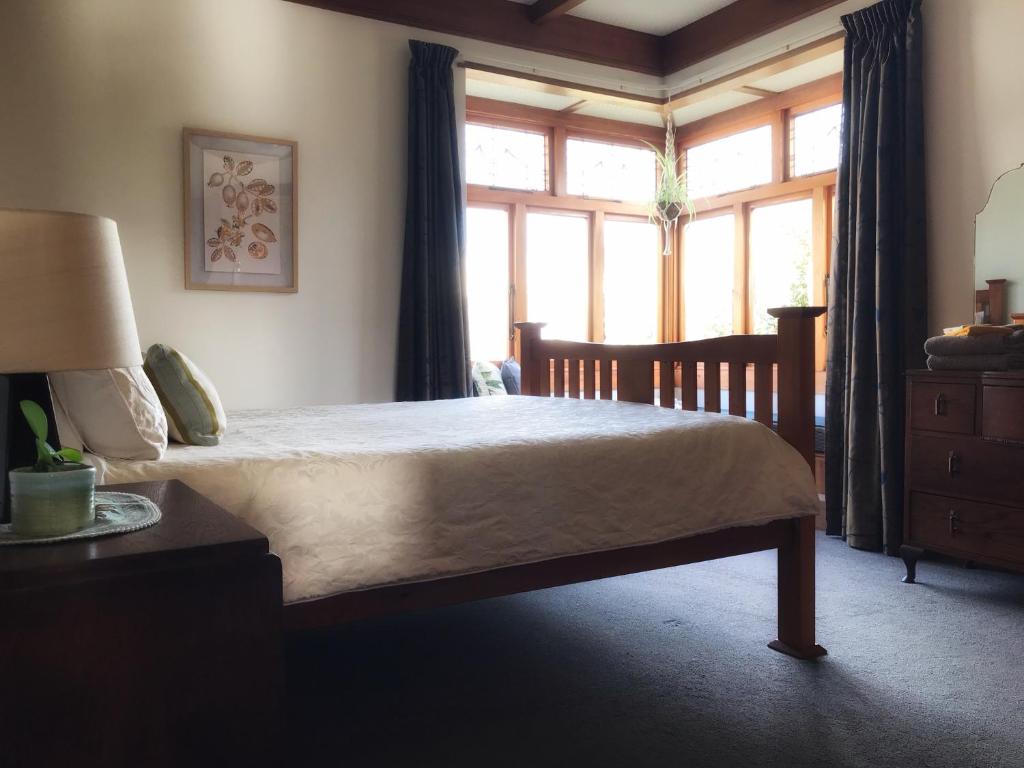 een slaapkamer met een bed en een groot raam bij 1920s Stay in Whanganui in Whanganui