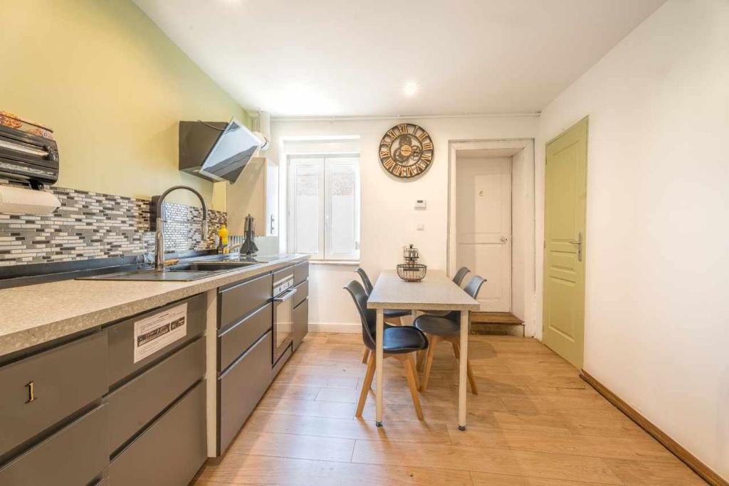 a kitchen with a table and a small table with chairs at Chambre 26m - Salon et kitchenette privé - WIFI in Woippy