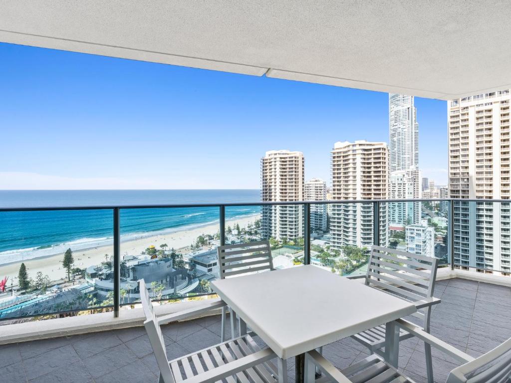 a table and chairs on a balcony with a view of the beach at H-Residences Private Apartments - Hosted by Coastal Letting in Gold Coast