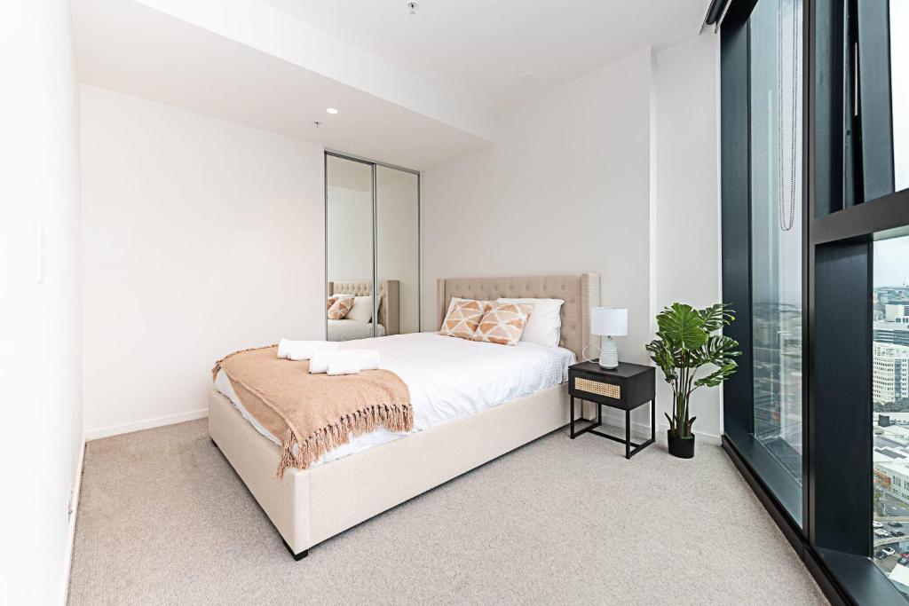 Un dormitorio blanco con una cama y una ventana. en Fantastic Urban Oasis, en Melbourne