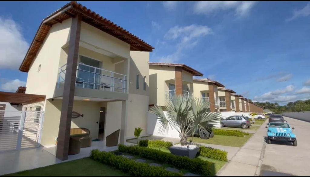 a house with a car parked in a parking lot at Casa em condomínio fechado in Barreirinhas
