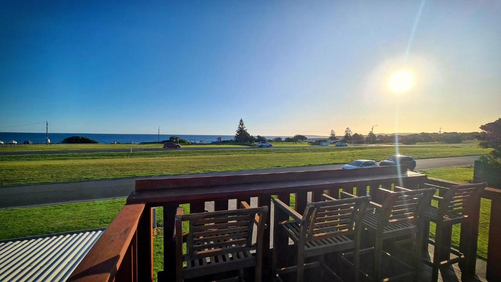 a bench on a balcony with a view of a field at Wheel chair & Pet Friendly Waterfront Retreat, 10 minutes to Phiilip Island, fireplace, wood supplied, WIFI wine & chocolates in Kilcunda