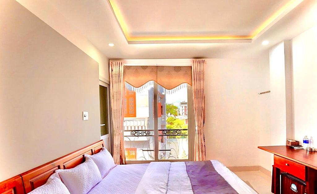 um quarto com uma cama e uma grande janela em Hotel Hoàng Thịnh em Da Nang