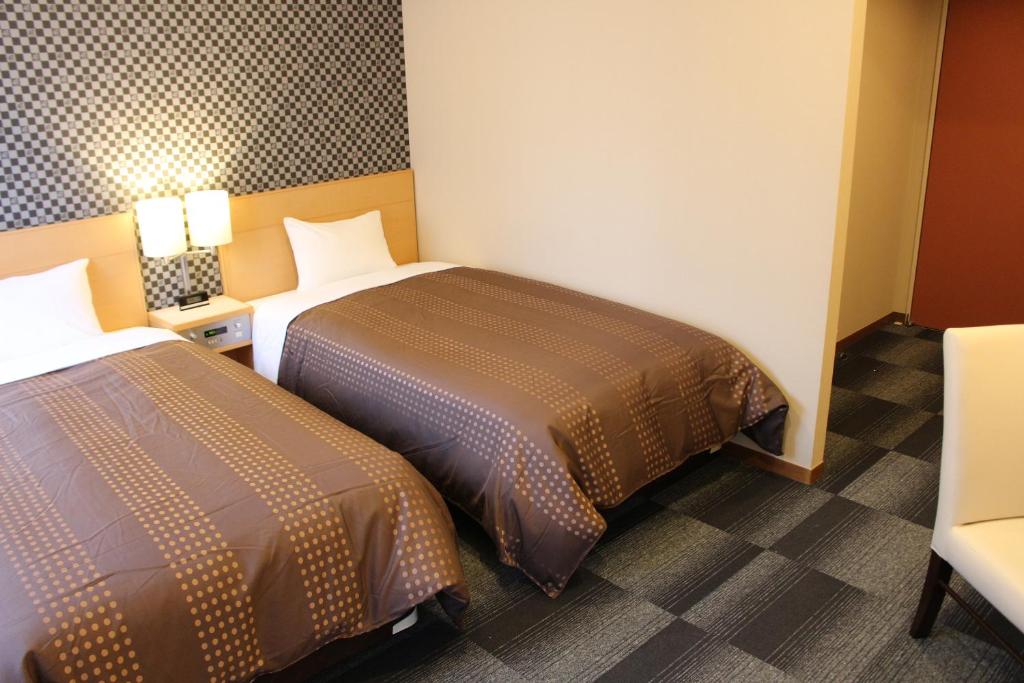 Postel nebo postele na pokoji v ubytování HOTEL LiVEMAX BUDGET Chiba Mihama