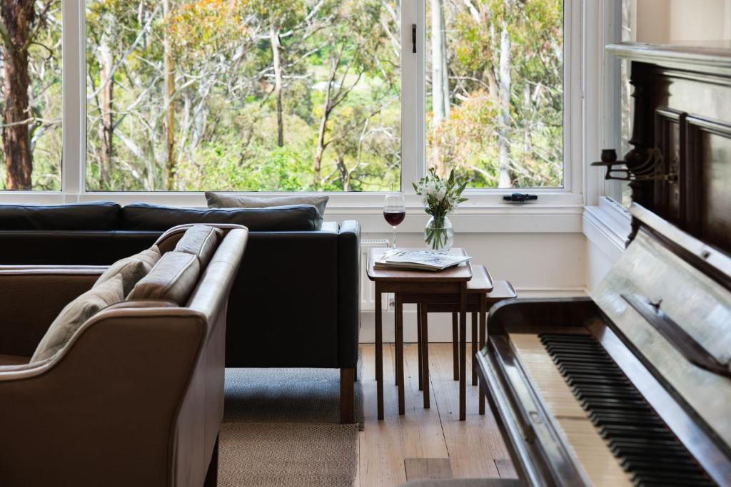 a living room with a couch and a piano at Annecy House in Daylesford