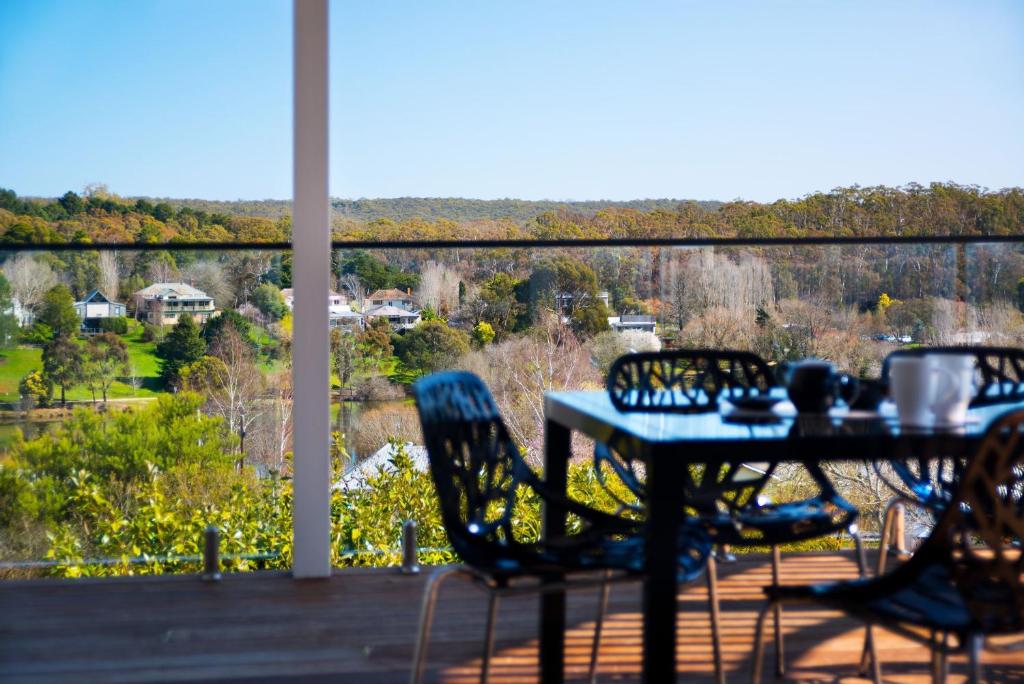 a table and chairs on a porch with a view at Aroona in Daylesford