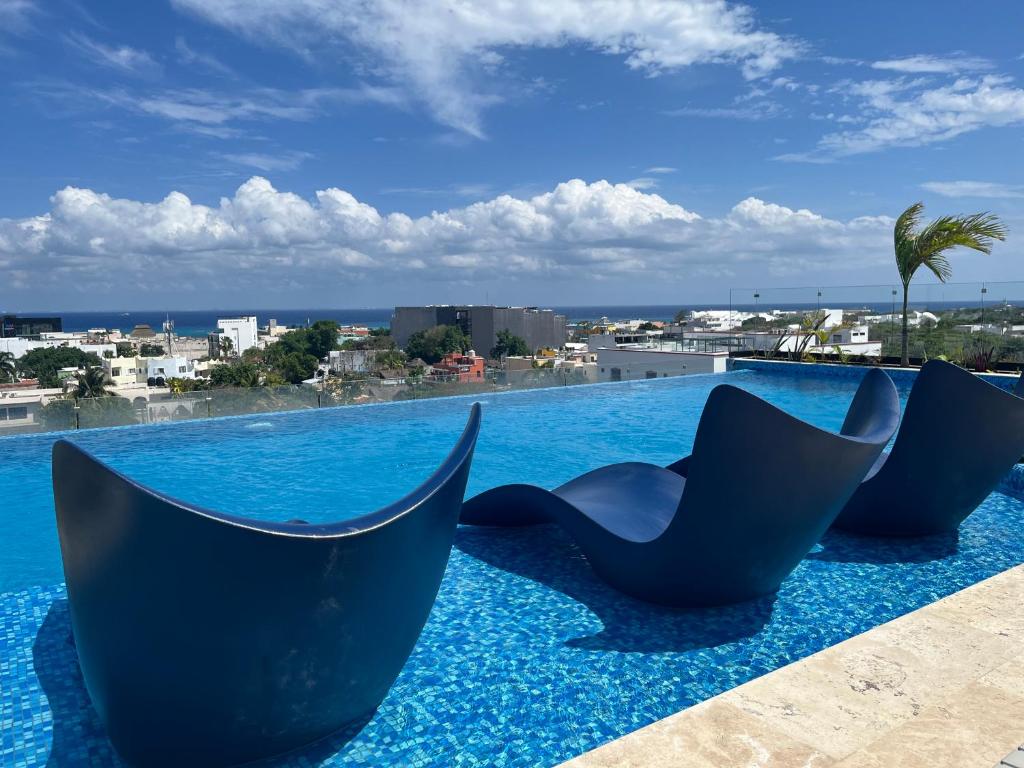 a pool with chairs on the roof of a building at Menesse Midtown 2 206 y 209 in Playa del Carmen