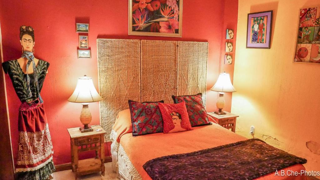 a bedroom with a bed with two lamps and a woman on the wall at Casona Rosa B&B, Morelia in Morelia