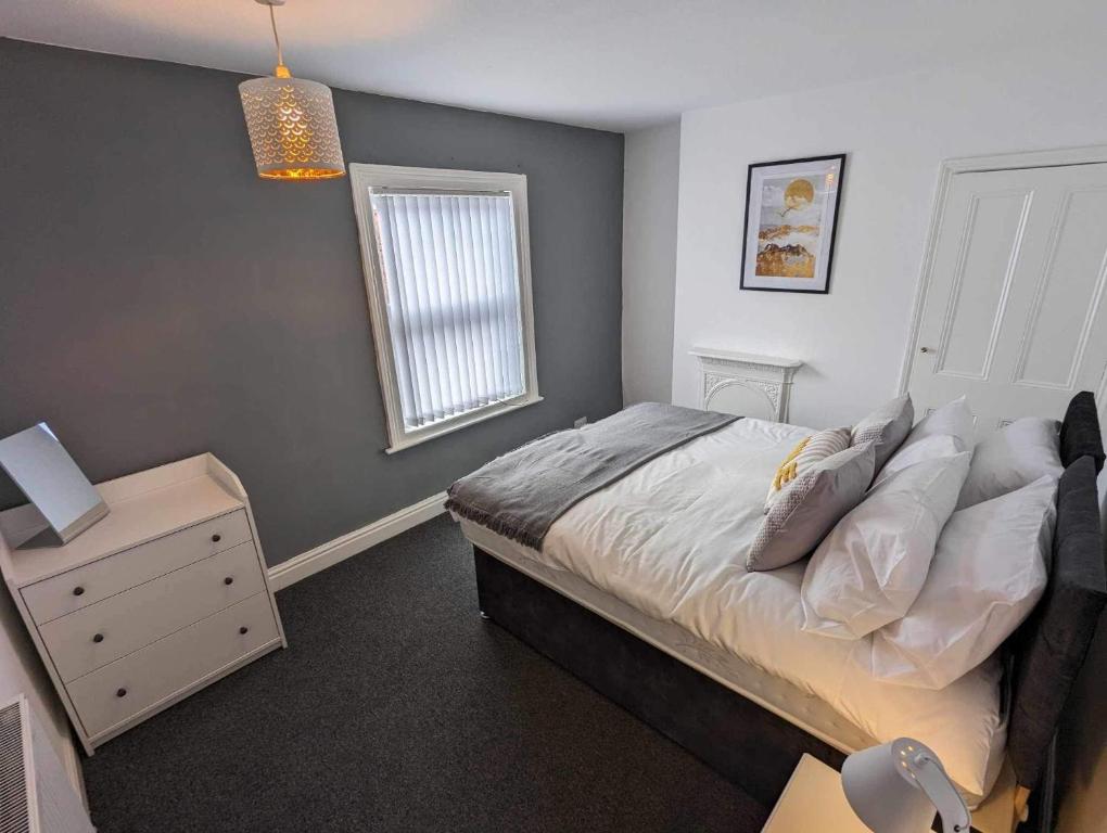 a bedroom with a bed and a nightstand and a window at Victoria House in Scarborough