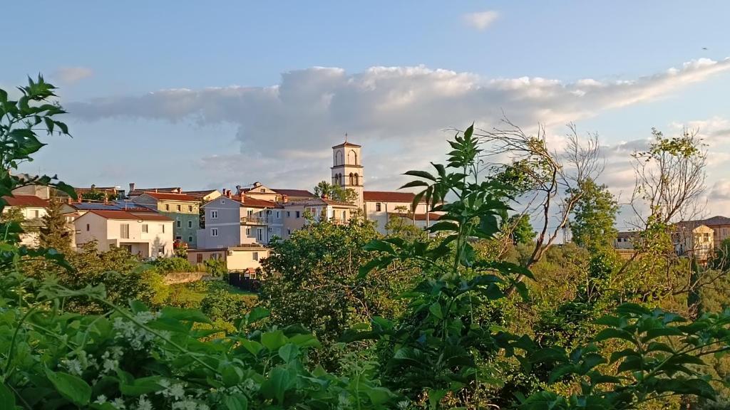 uma vista para uma cidade com uma torre sobre uma colina em Apartmaji Hrvatin v Kortah em Izola