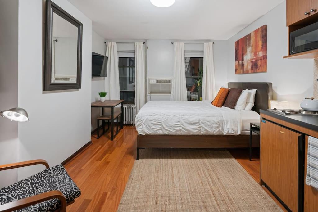 ein kleines Schlafzimmer mit einem Bett und einer Küche in der Unterkunft Great Studio Location in Times Square Near Subway in New York