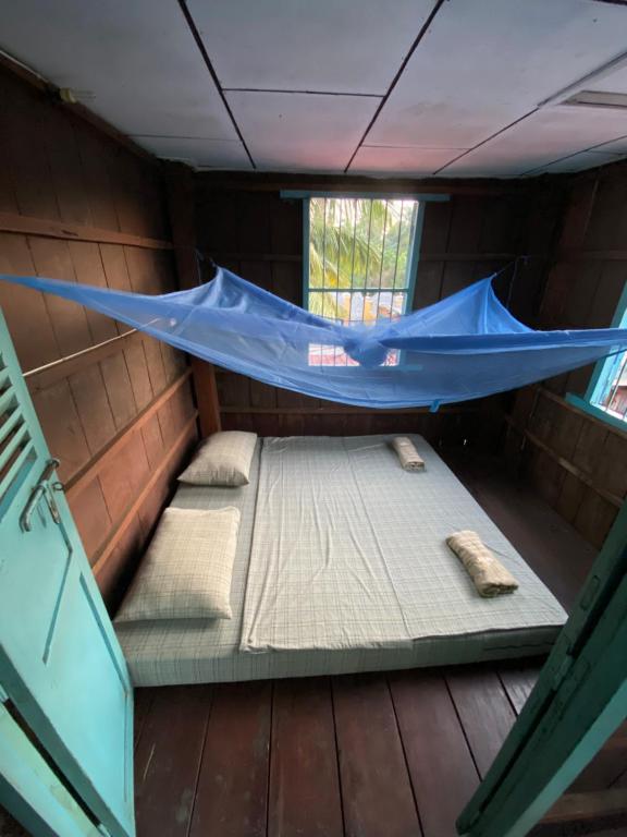 a room with a bed and a hammock in it at Lazy Mango Home Stay in Phumĭ Poŭthĭ Mâ Srei