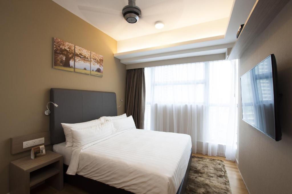 a bedroom with a white bed and a window at Suasana Suites Bukit Ceylon in Kuala Lumpur