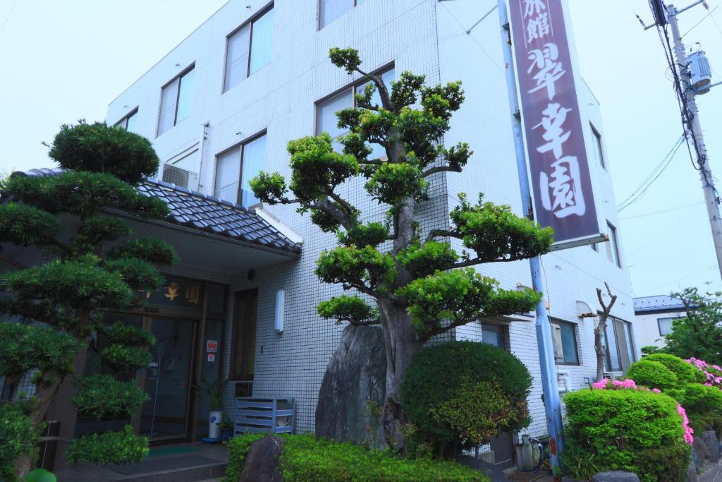 a pine tree in front of a building at Suikoen in Yonago