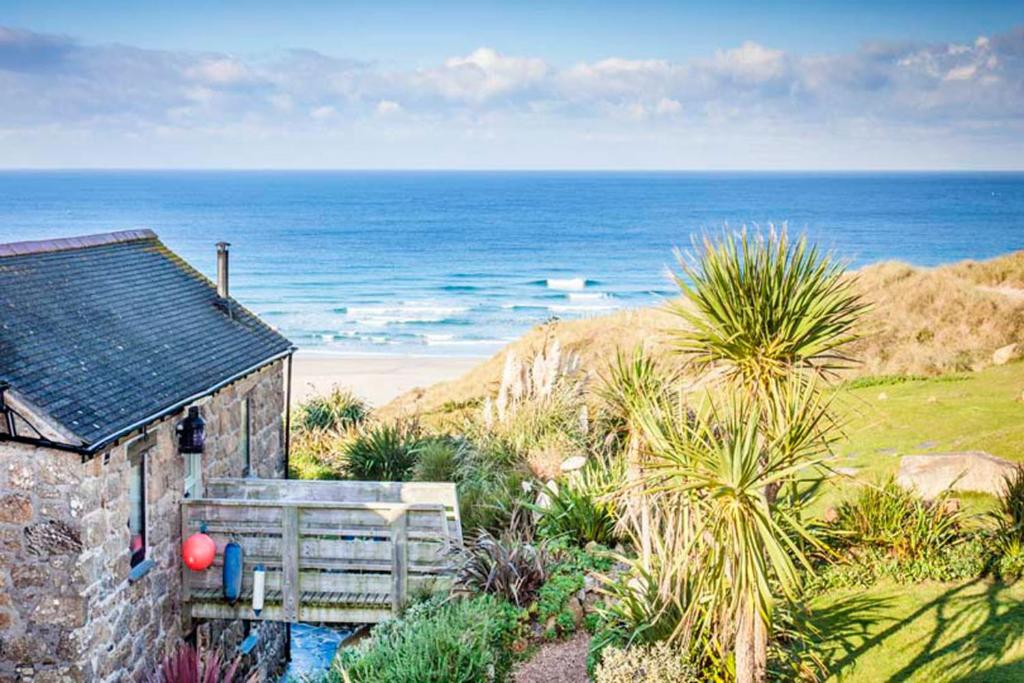 a small house with a view of the ocean at Girl Annie, Cornish Cottage With Superb Sea Views & Garden, By Beach in Sennen