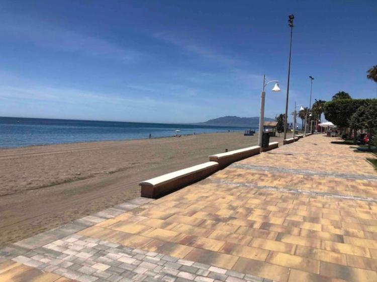 une plage de sable avec une lumière de rue et l'océan dans l'établissement Ático en la playa con terraza privada, à Cala del Moral
