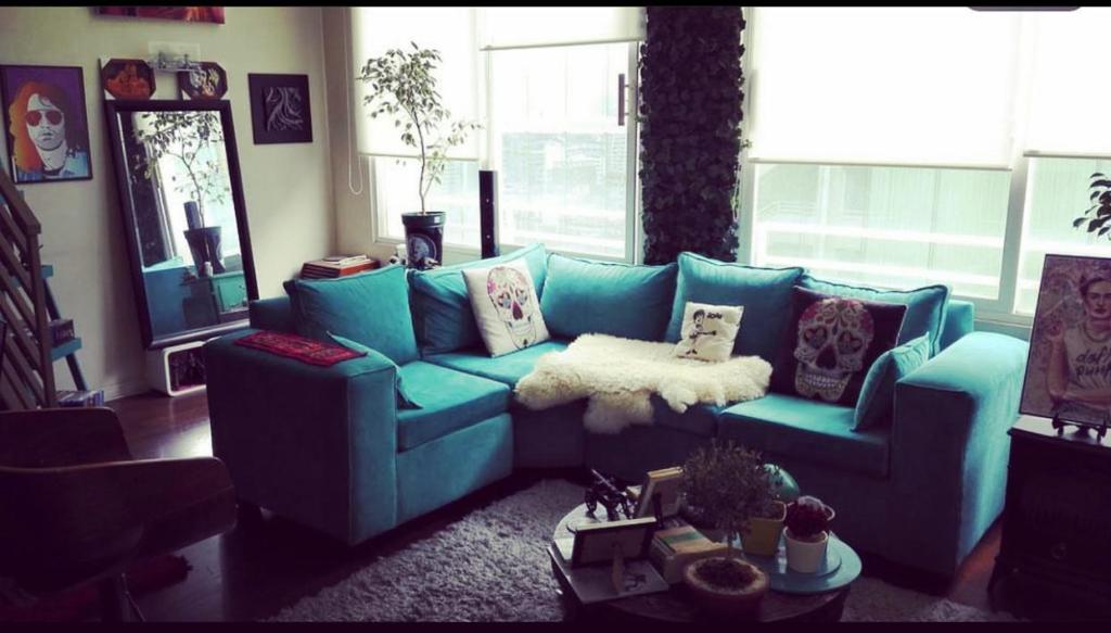 sala de estar con sofá azul y almohadas en APART SANTIAGO, en Santiago
