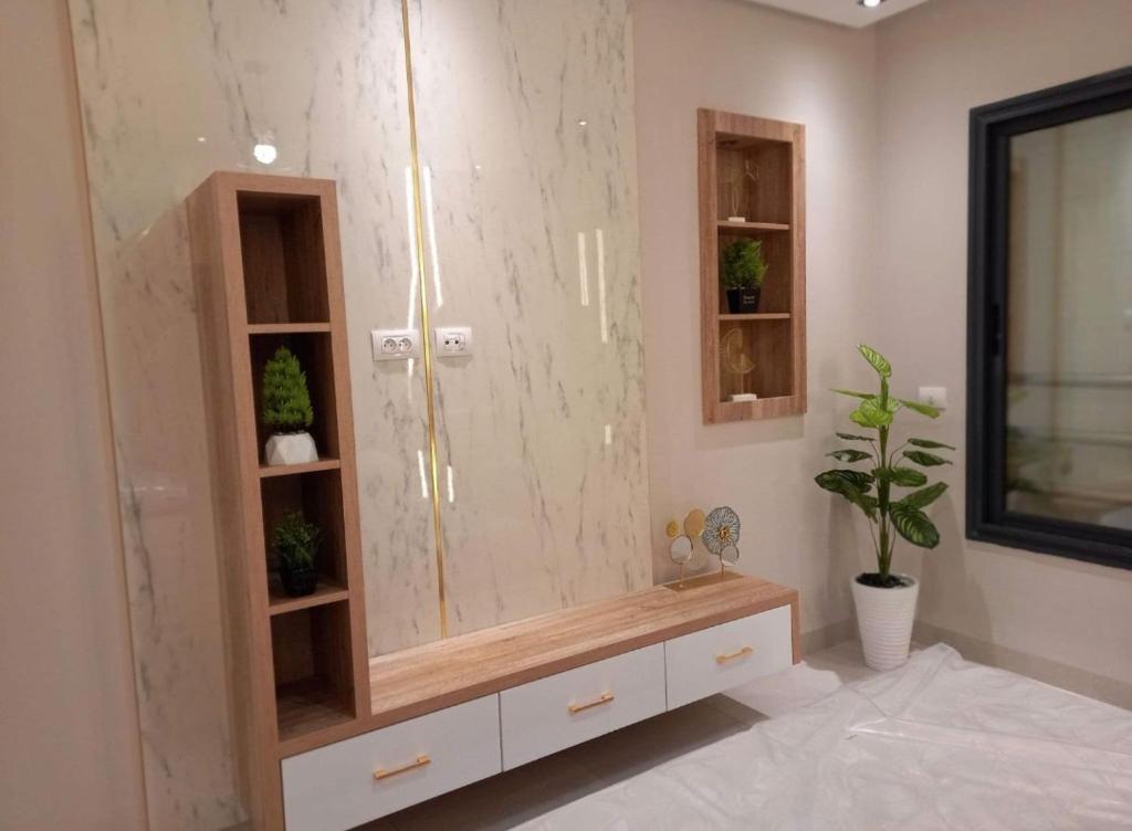 a bathroom with a shower with a sink and a mirror at Modern apartment kantaoui sousse in Dar el Saïd