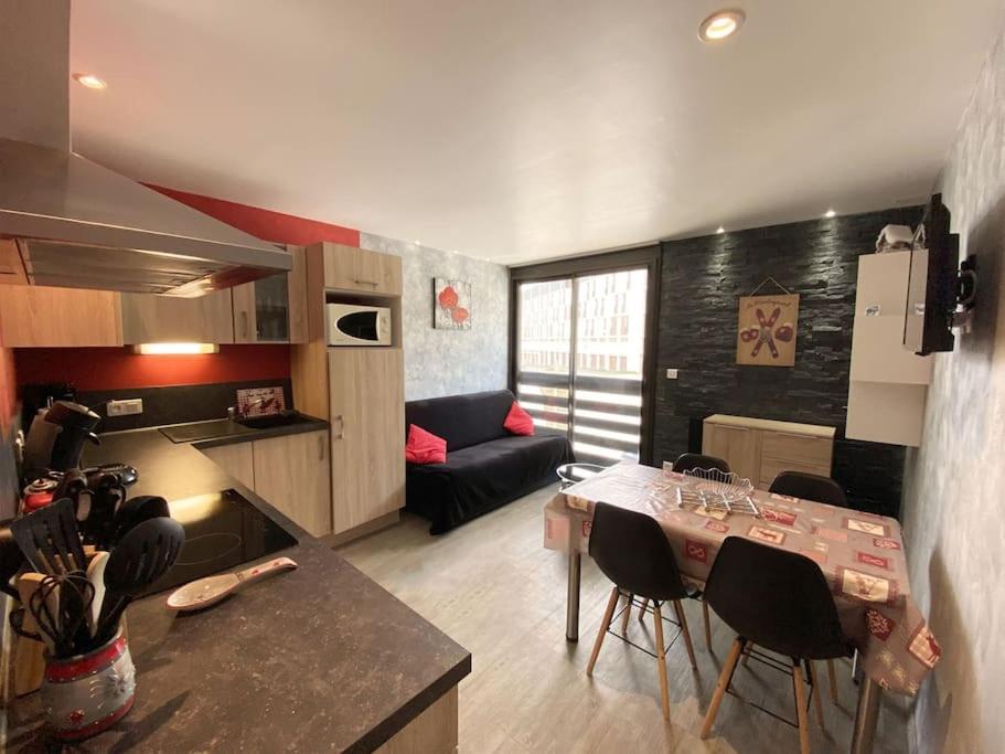 une cuisine et un salon avec une table et des chaises dans l'établissement Appartement à la montagne au pied des pistes Classé 3 étoiles, à Saint-Lary-Soulan