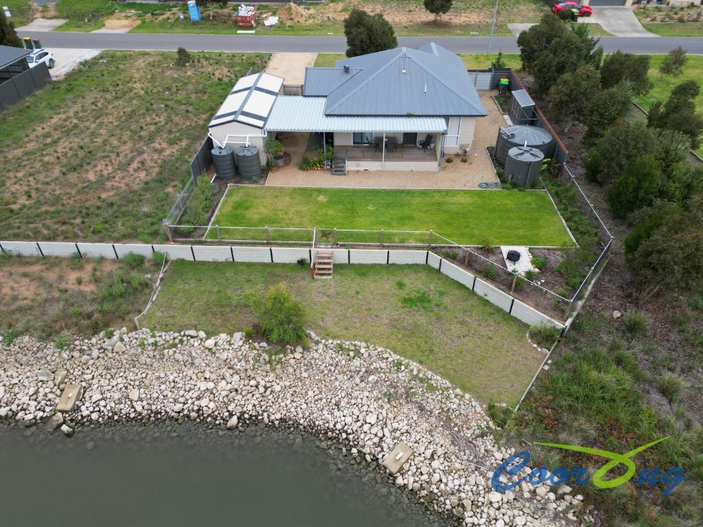 an aerial view of a house with a dock and water at River Dais in Wellington East