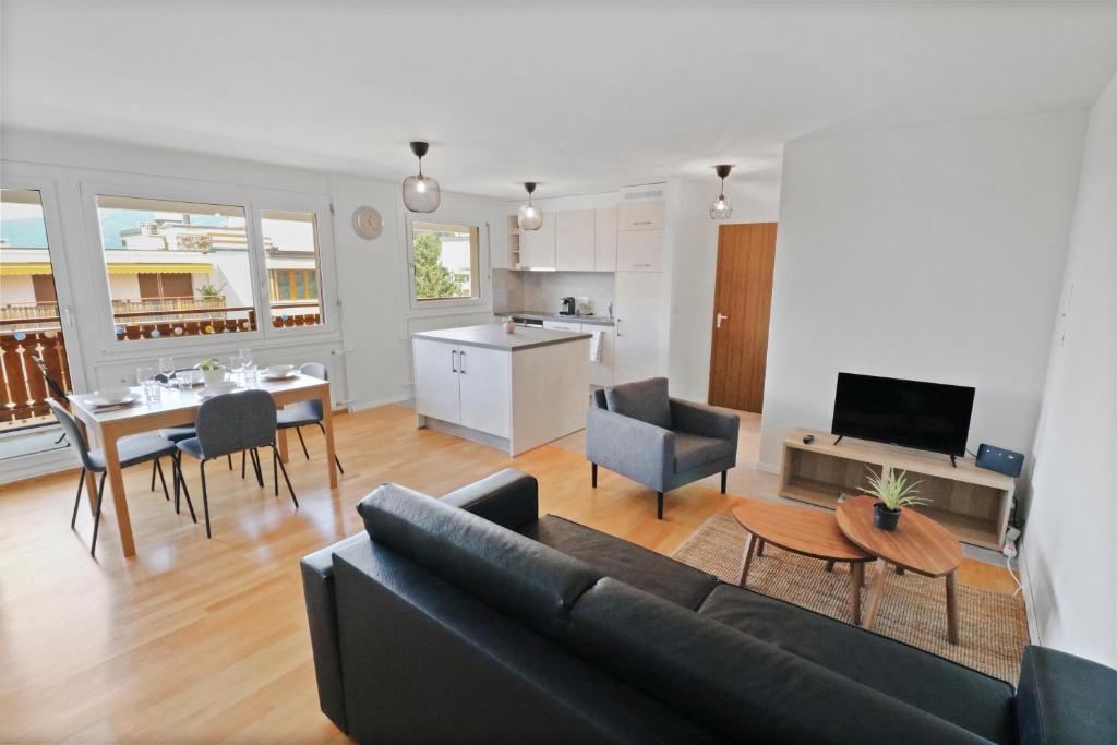 克萊恩 蒙塔納的住宿－Appartement central et confortable，客厅以及带沙发和桌子的厨房。
