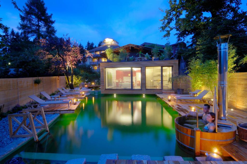 a pool in a backyard with a house at Hotel Moserhof in Seeboden