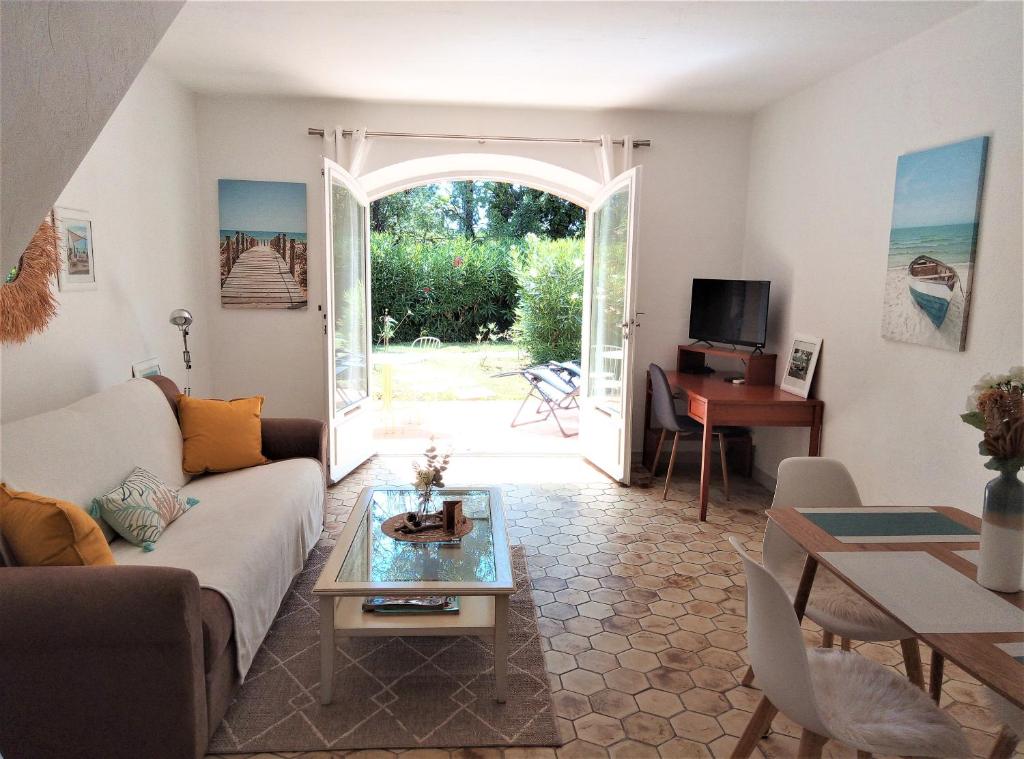 ein Wohnzimmer mit einem Sofa und einem Tisch in der Unterkunft Appartement 10 en duplex - LES SUITES DE ROBINSON - Résidence avec piscine en bord de Siagne, à Mandelieu-La-Napoule in Mandelieu-la-Napoule
