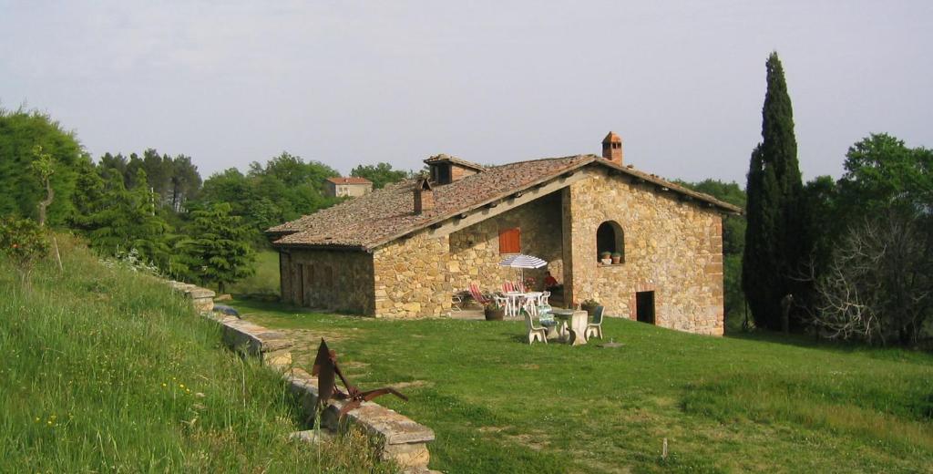 a building with a table and chairs in front of it at Casale Fornello in Acquapendente