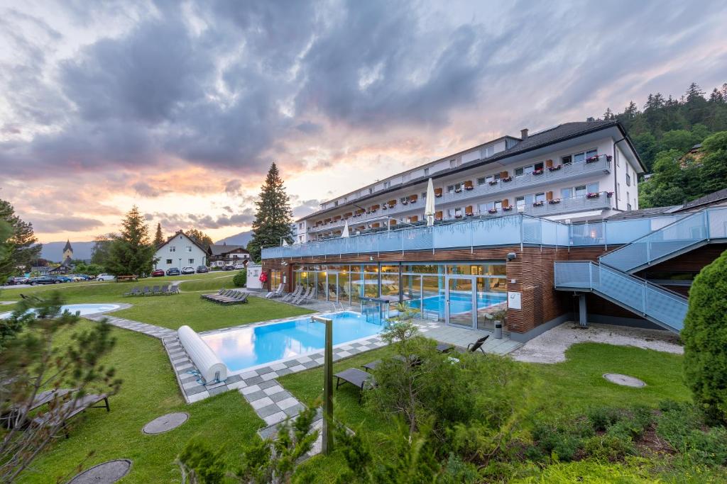 ein Hotel mit einem Pool und einem Gebäude in der Unterkunft Hotel-Restaurant Grimmingblick in Bad Mitterndorf