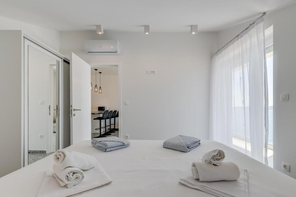 una camera bianca con due asciugamani su un bancone di Deluxe Villa KENNEDY a Mimice