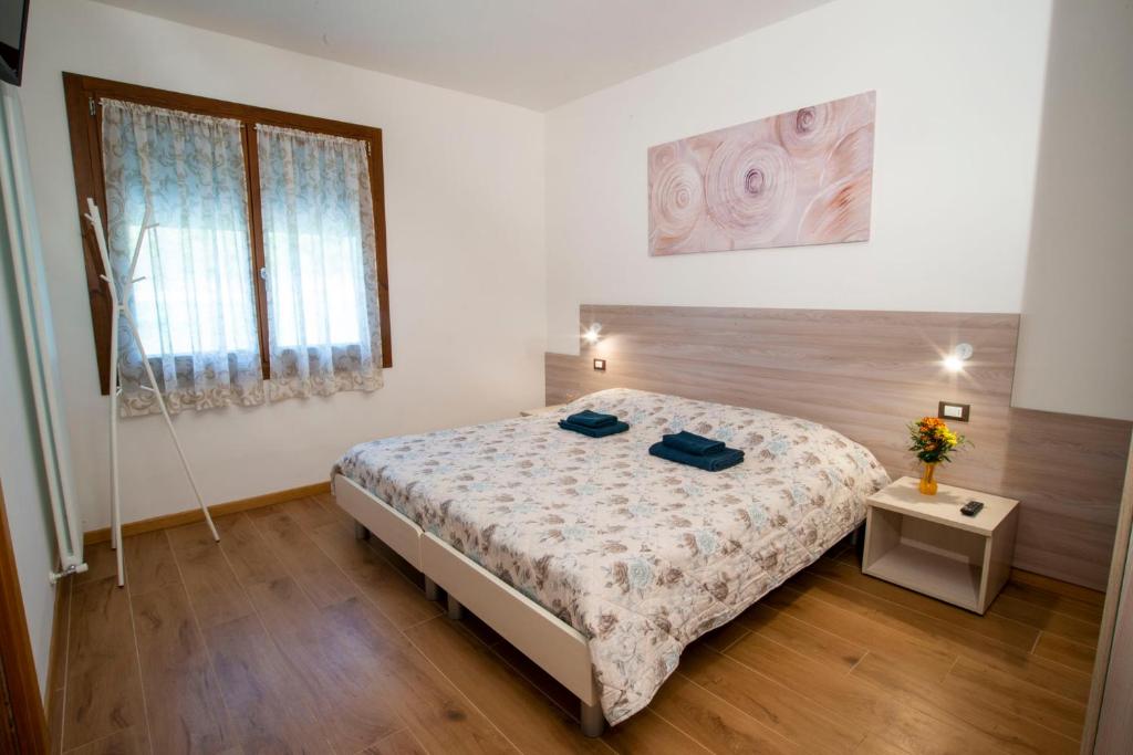 - une chambre avec un grand lit et une fenêtre dans l'établissement Ca' dei Berici, à Tormeno